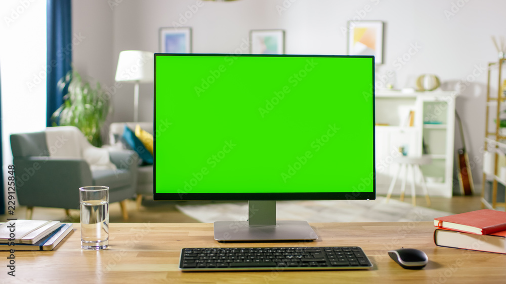 现代个人电脑，带实体绿屏显示器，放在舒适家居的桌子上