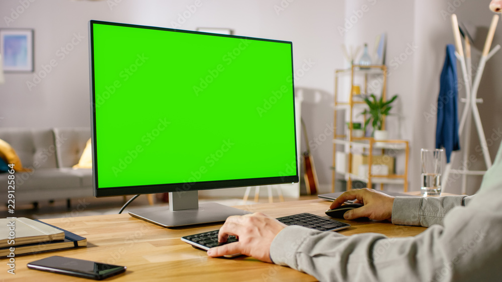 职业自由职业者在绿色实体屏幕个人电脑F上工作的肩扛镜头