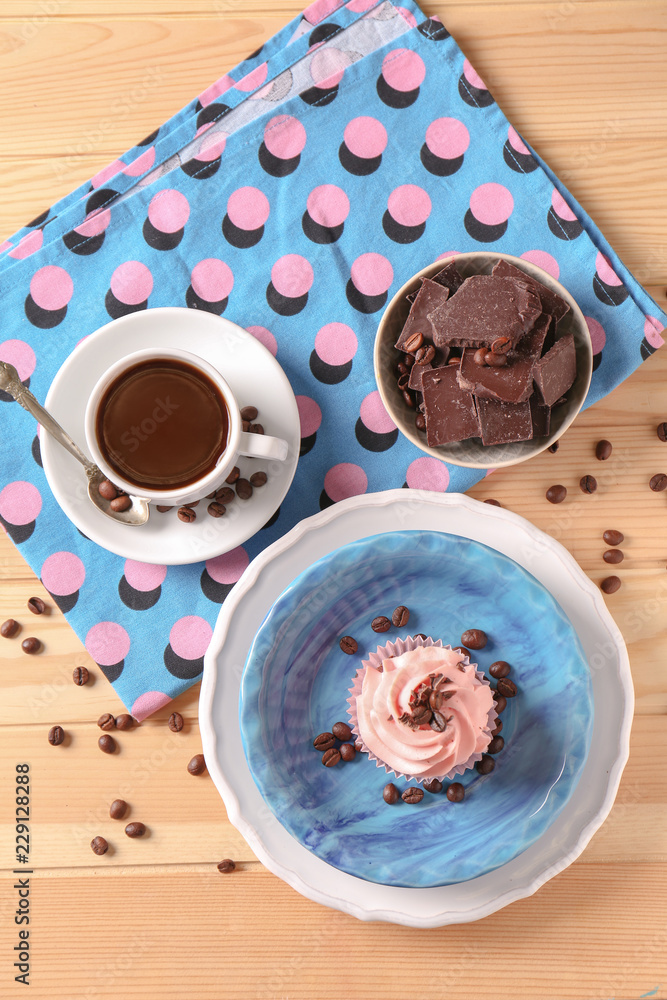 木桌上放着巧克力和咖啡的甜纸杯蛋糕