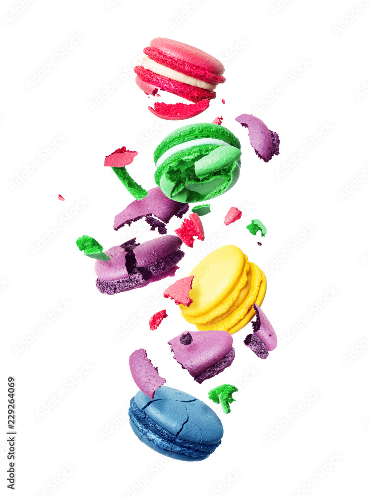 Сolored macaroons is torn to pieces in the air,  isolated on a white background