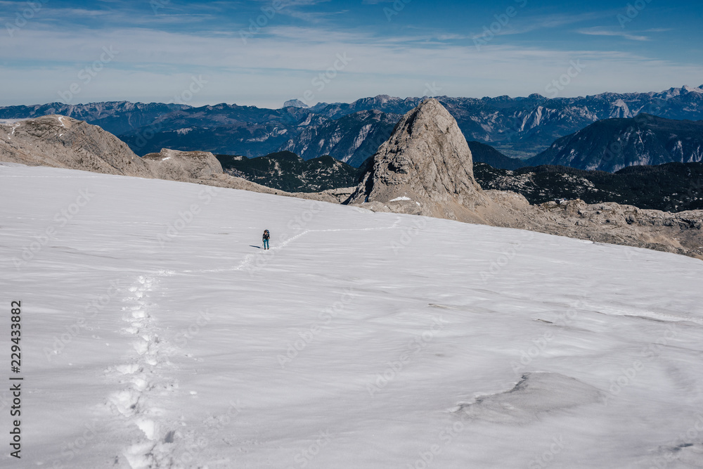 徒步旅行者或登山者登上有裂缝的冰川。达赫斯坦冰川和斯诺上的登山者