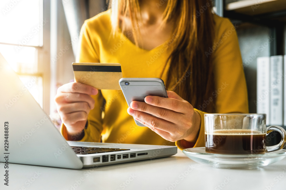 女商人手动使用智能手机、平板电脑支付和持有信用卡在线购物，无处不在