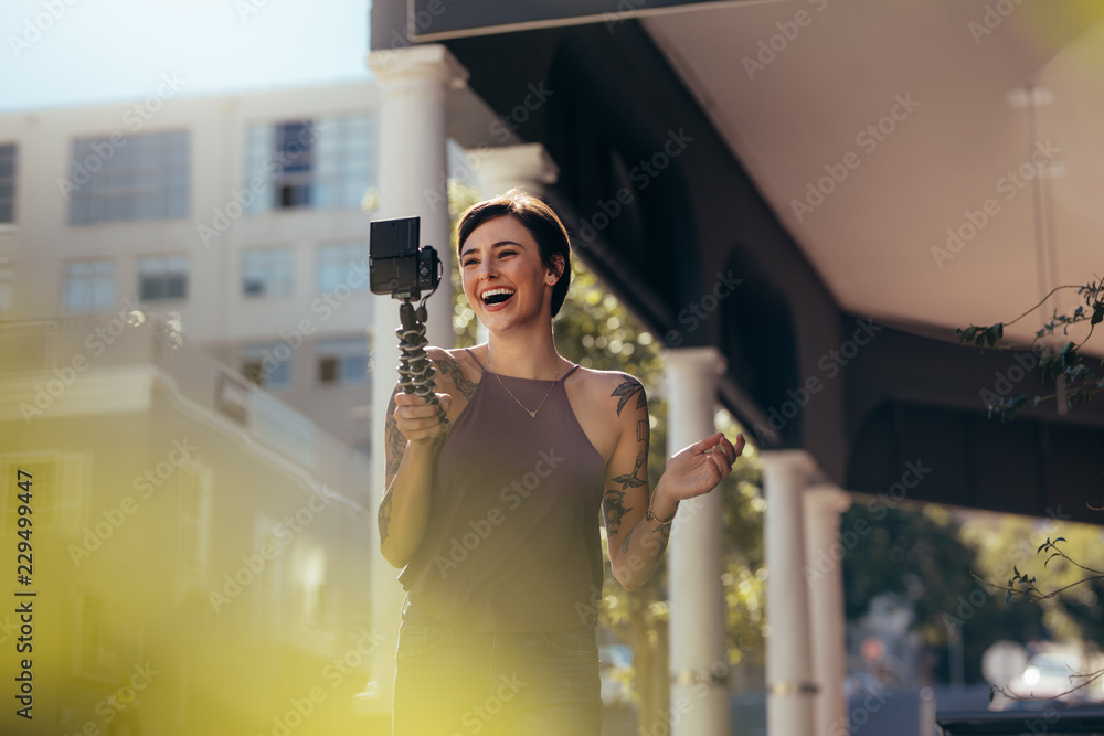 大笑的女人在户外录制视频日志