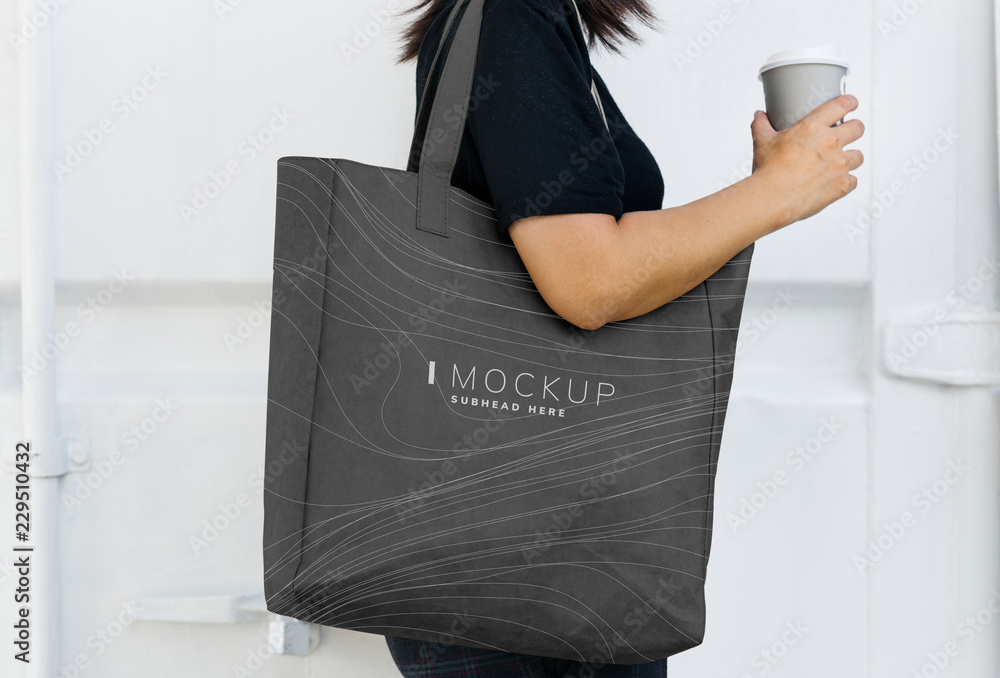 一个女人拿着一个黑色购物袋模型