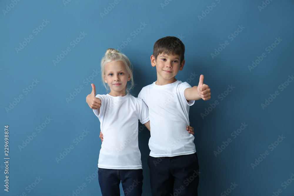 穿着t恤衫的男孩和女孩在彩色背景上显示拇指向上的手势
