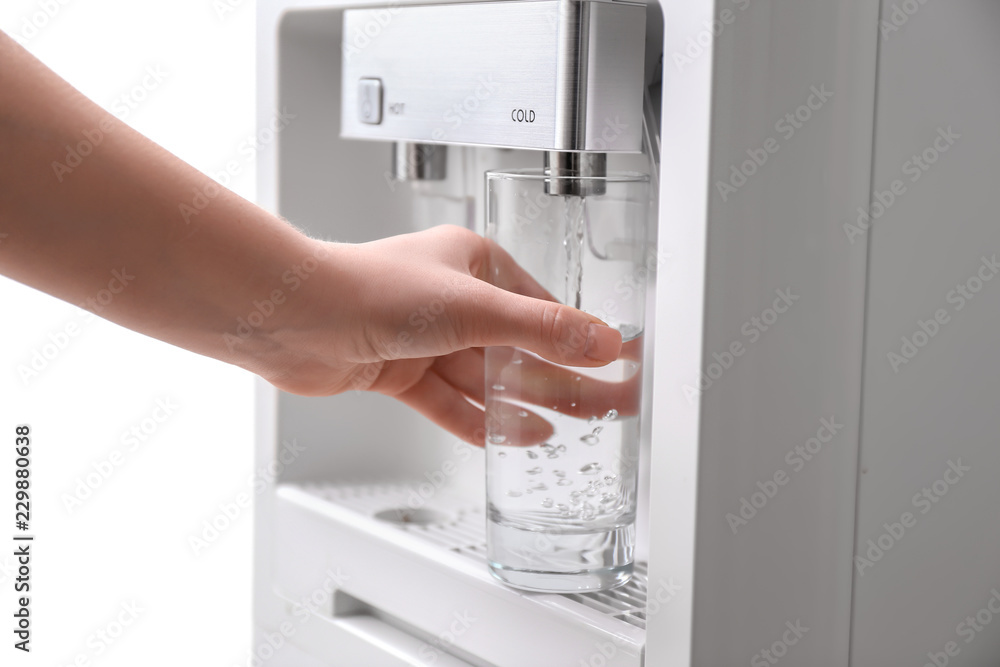 一名妇女从冷却器往杯子里加水，特写镜头