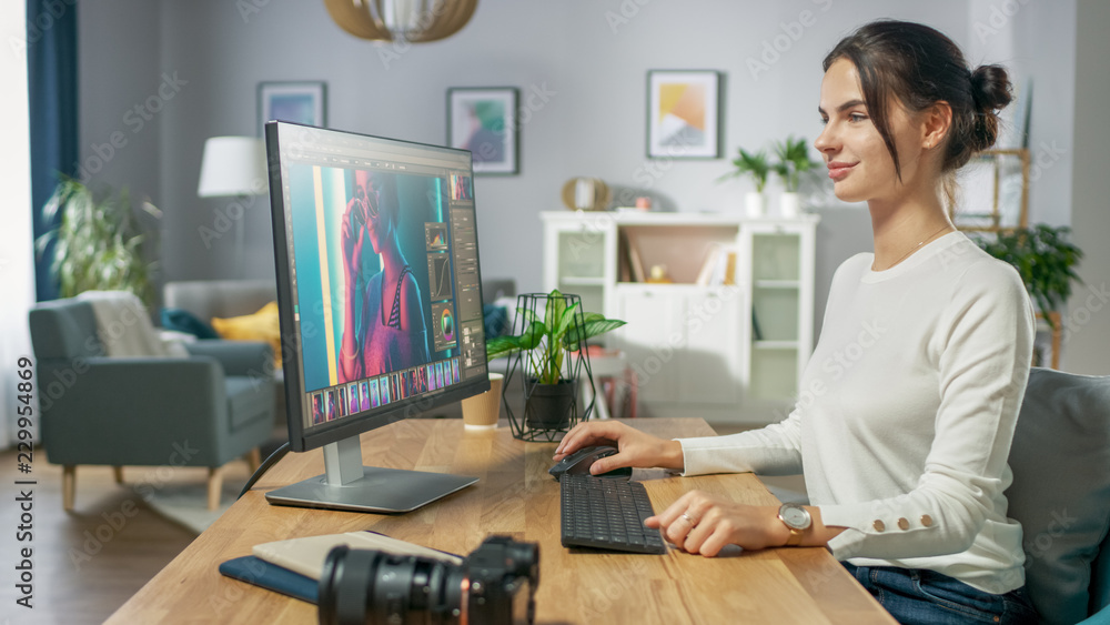 专业女性摄影师在个人电脑上使用照片编辑应用程序/软件。Pho