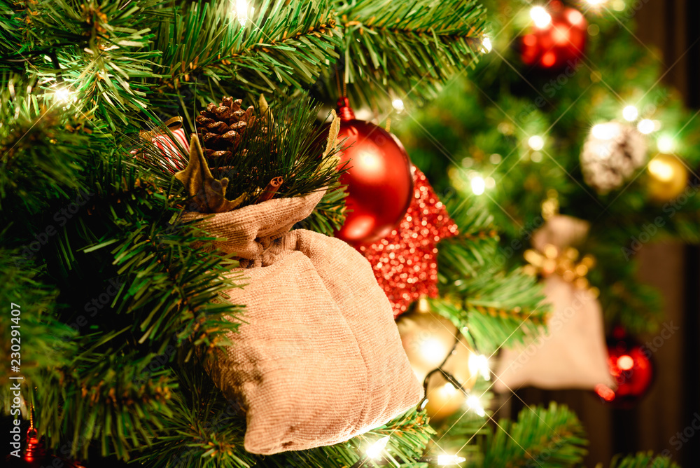 用圣诞老人玩偶、圣诞球和灯光装饰的圣诞树特写