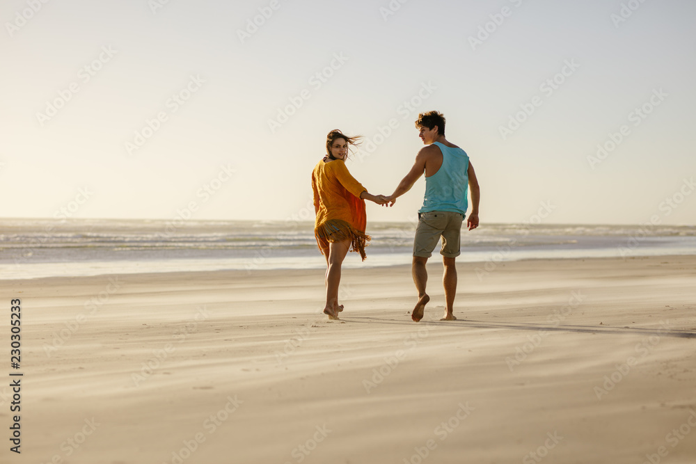 情侣牵着手走在海滩上