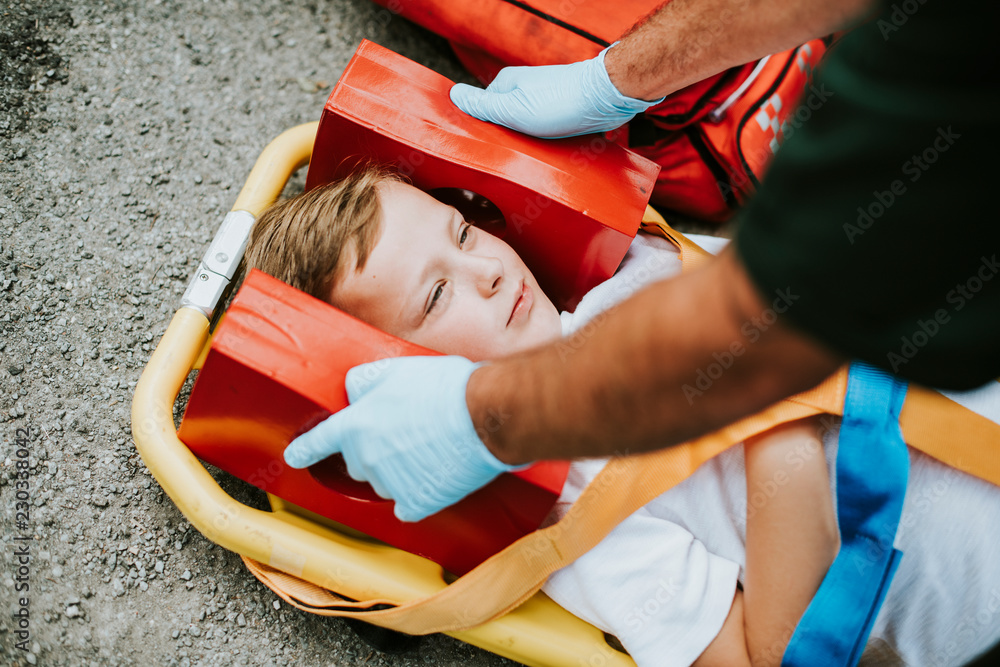 躺在救护车担架上的年轻受伤男孩