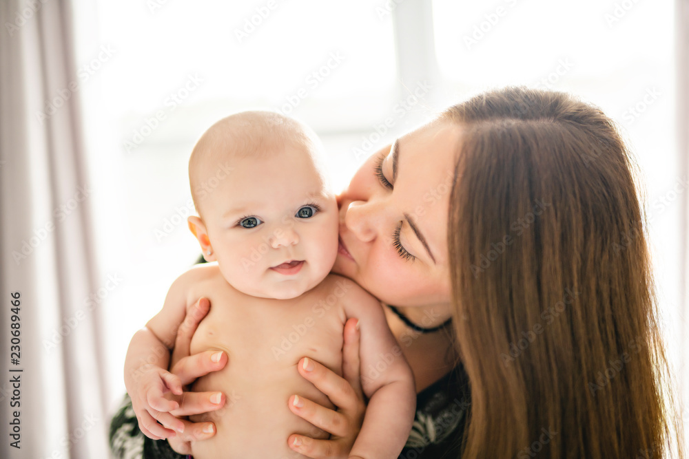 A Portrait of happy baby with cheerful mother at home bedroom