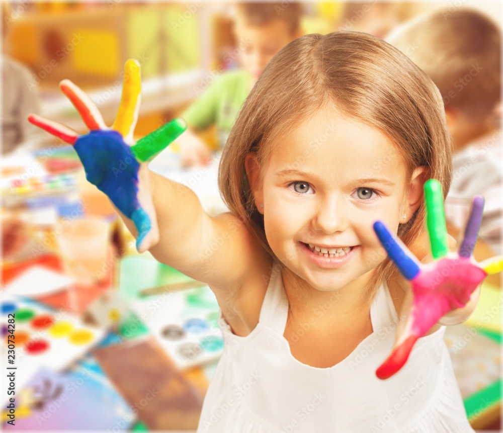 课堂背景上画着五颜六色的手的可爱小女孩