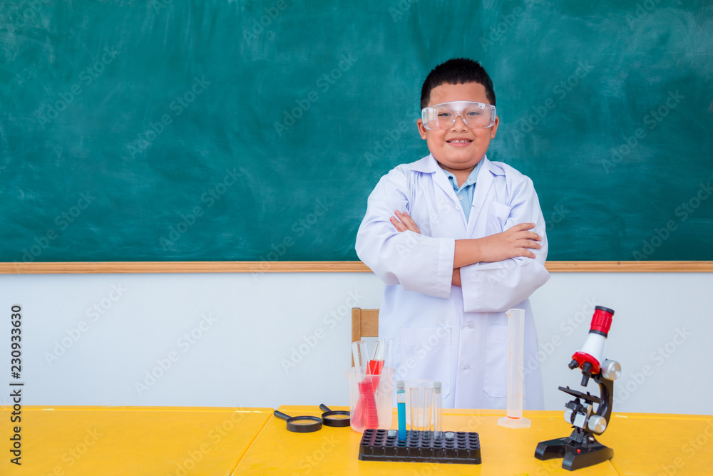 年轻的亚洲学生站在科学教室里微笑