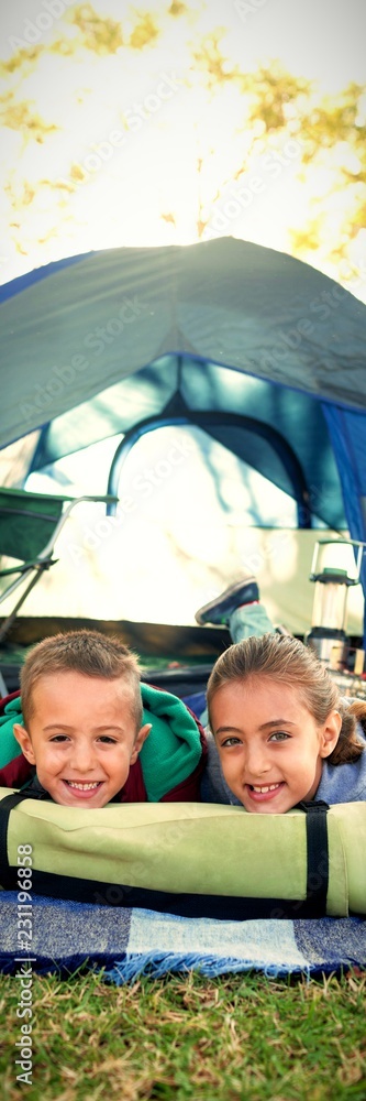 微笑的兄弟姐妹躺在帐篷外
