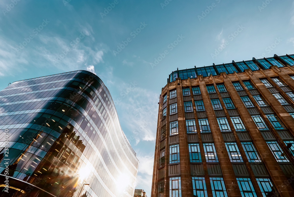 Modern offices and old middle of XX century buildings neighborhood with blue sky background.