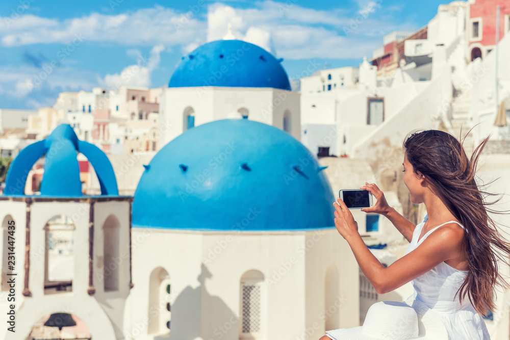 旅游游客在电话里拍摄圣托里尼蓝色圆顶教堂，欧洲旅游景点，E