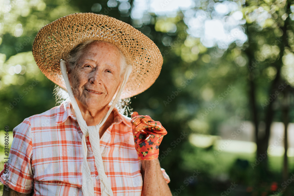 一个戴着草帽的快乐老年妇女的画像