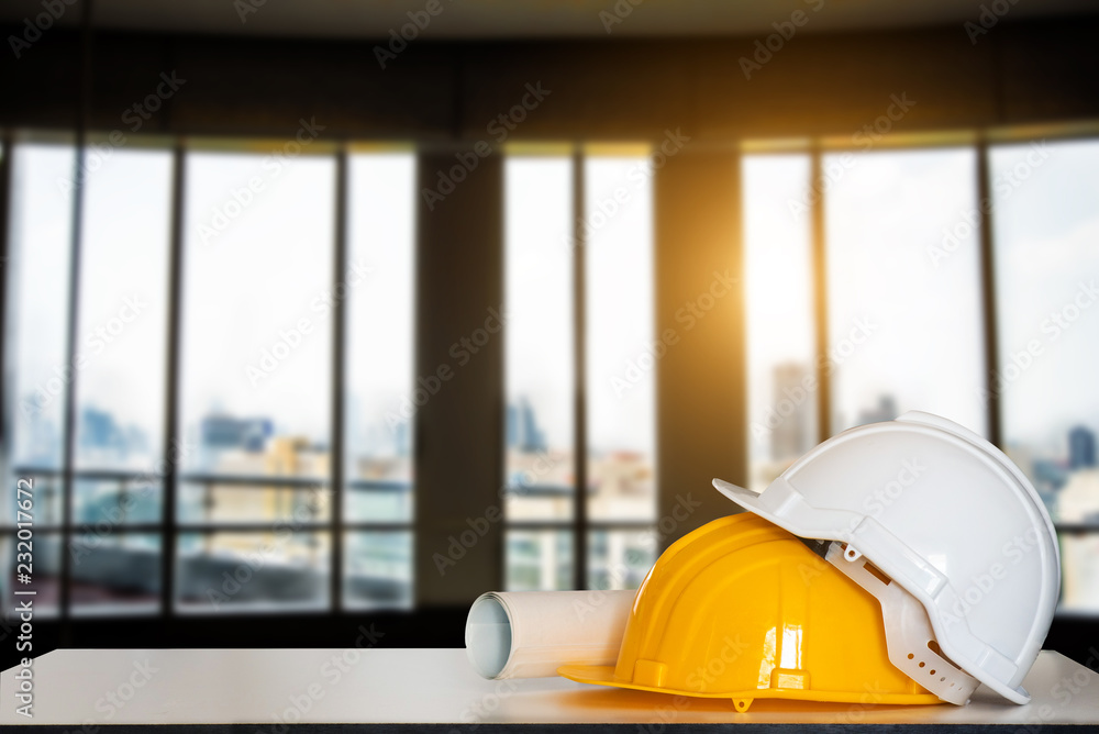 建造房屋和建筑物。维修工作。白色桌子上的建筑物和头盔图纸。