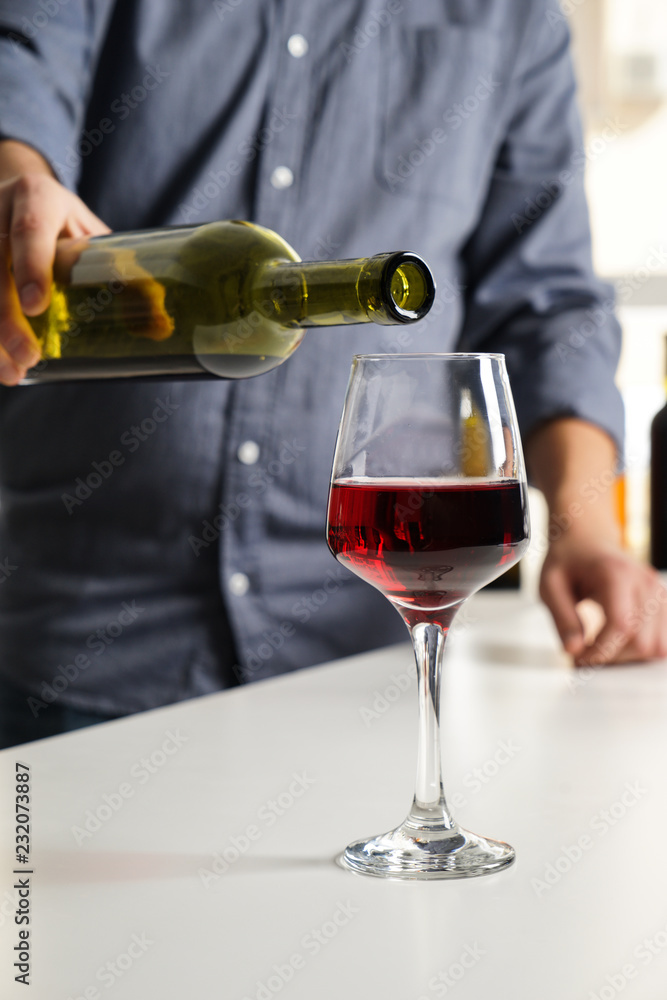 酒吧服务员在派对上往杯子里倒美味的葡萄酒
