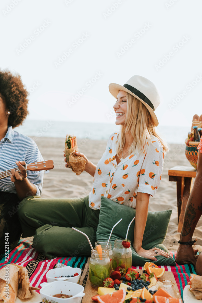 海滩野餐时吃三明治的女人