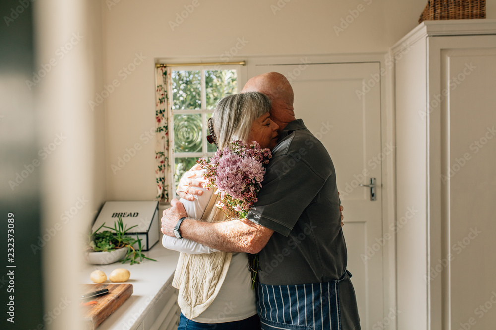 老年夫妇站在家里拥抱