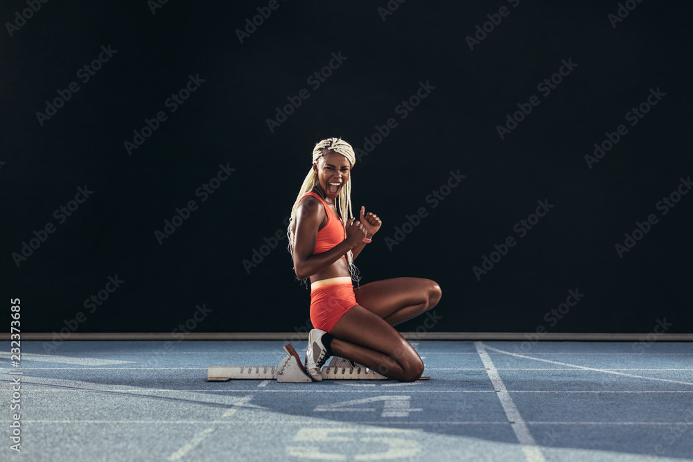 女子短跑运动员在sta上摆姿势时竖起大拇指