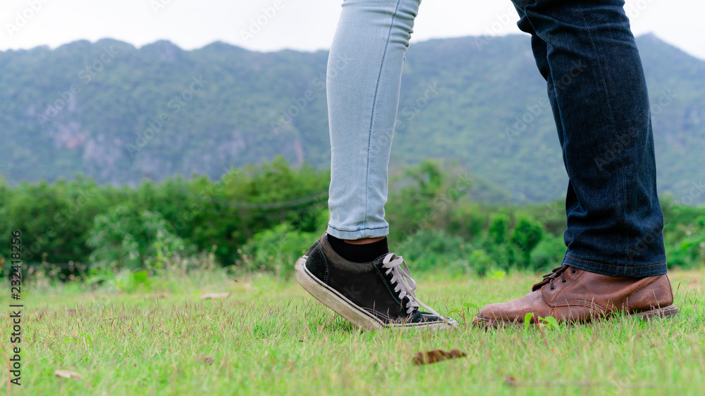 Happy couple take a romantic walk in green grass field on the hills. Travel and honeymoon concept.