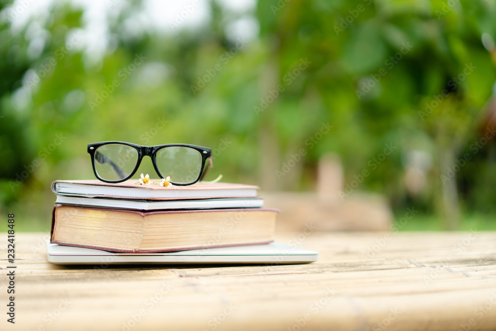Soft focus retro style books and eye glasses with nature background. Reading and education concept.