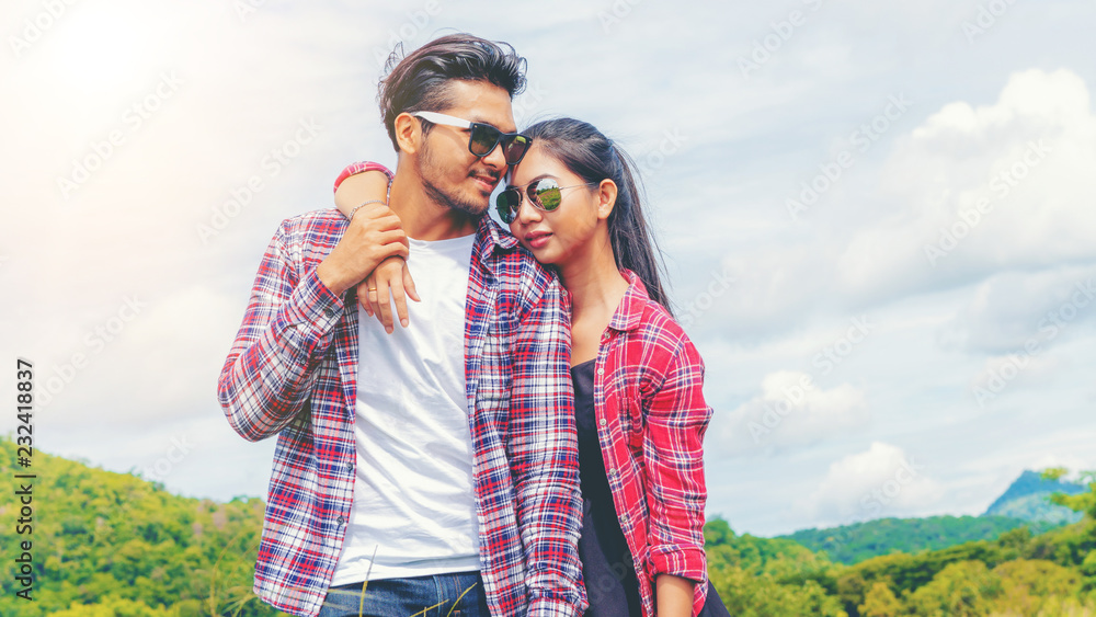 幸福的一对情侣在山上的绿草地里浪漫地散步。旅行和蜜月的概念。