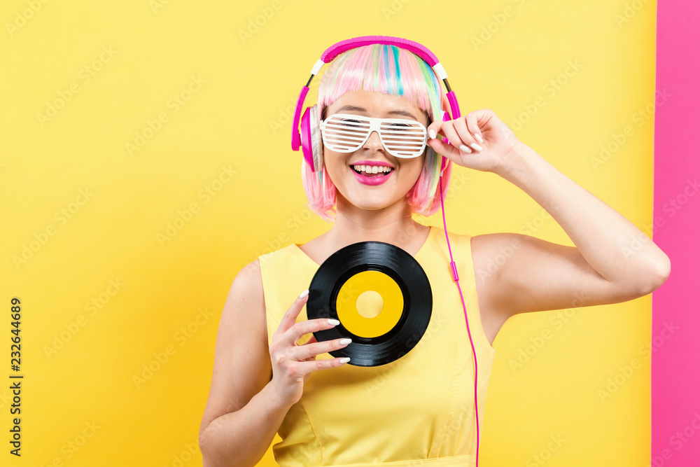 戴着彩色假发的女人拿着一张黄粉相间的黑胶唱片