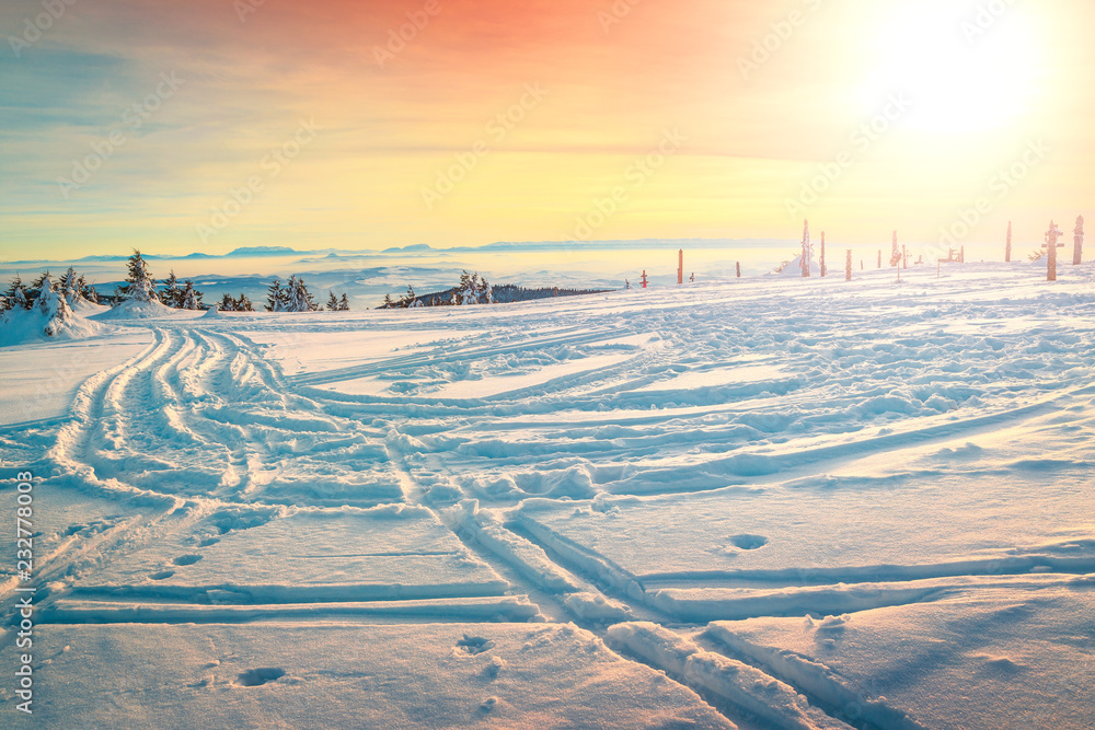 美丽的冬季日落景观和积雪覆盖的道路