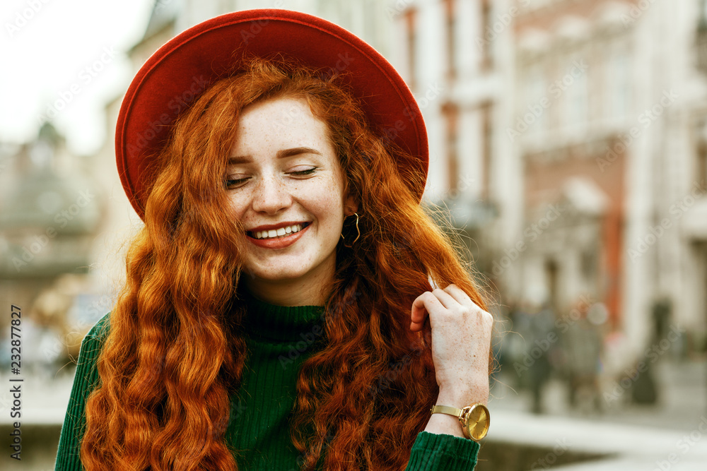 年轻美丽时尚快乐微笑的红头发女人的特写肖像，长着雀斑，很长