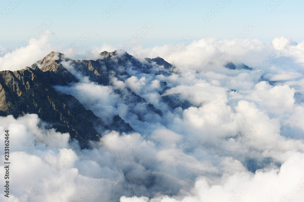 Alpine landscape with peaks covered by snow and clouds