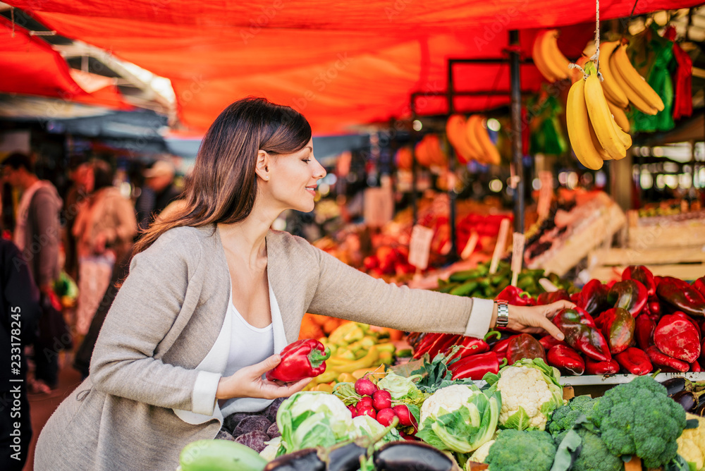 健康的生活方式。迷人的女人在农贸市场买蔬菜。