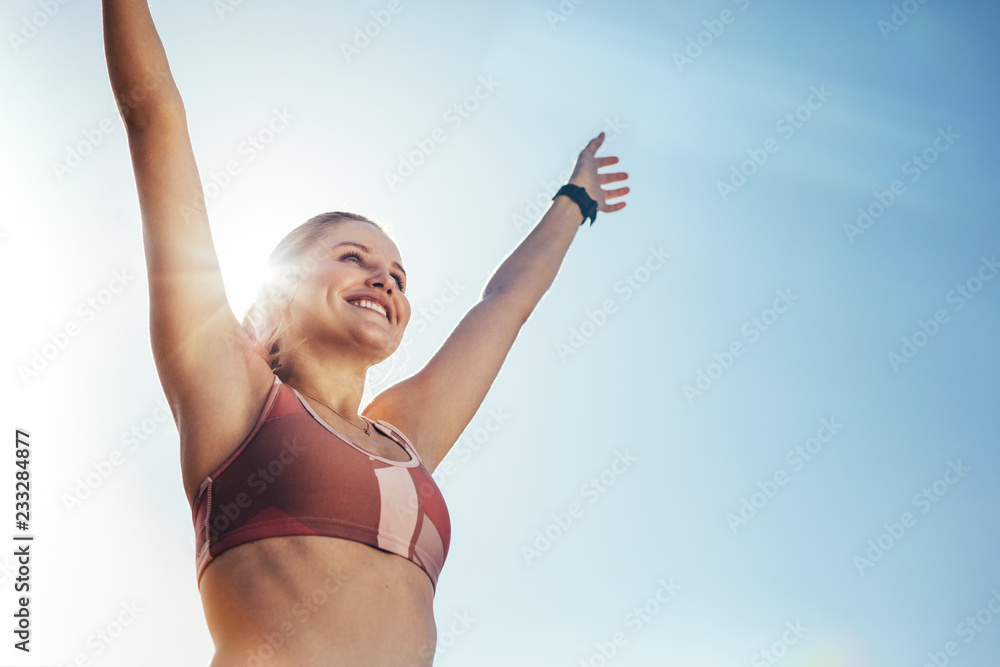 微笑的健身女性举起双臂进行锻炼