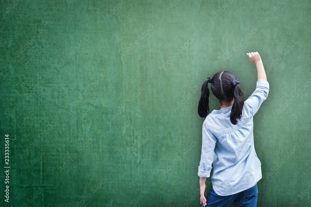绿色教室黑板背景，学生孩子的背面在黑板上写字，用于空白复印水疗