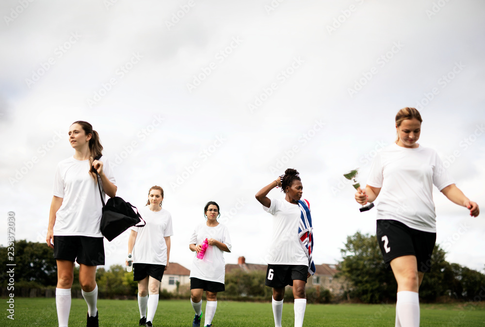 青少年女子足球运动员在球场上行走