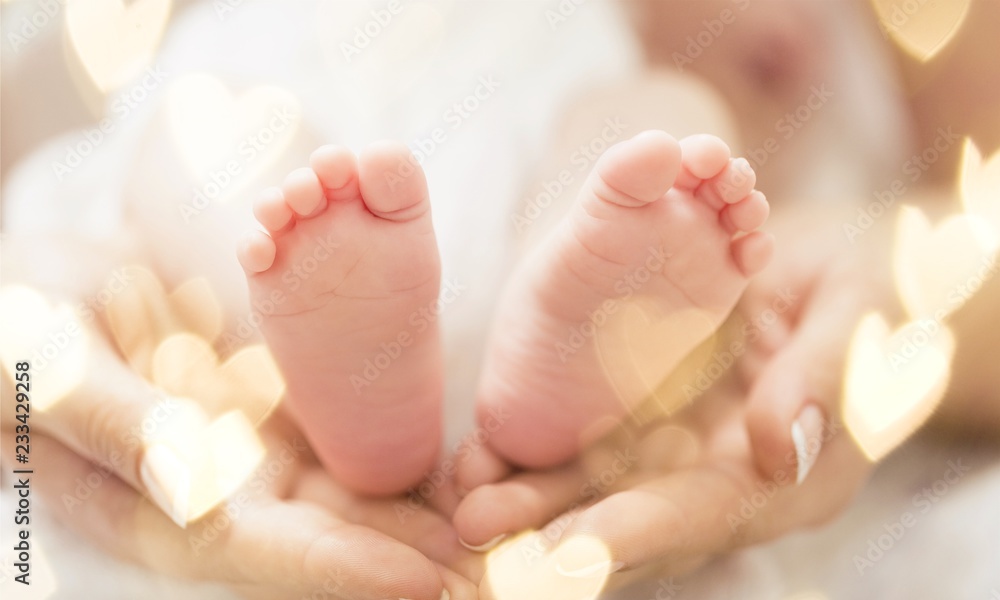 婴儿的脚在温柔的母亲手中，特写