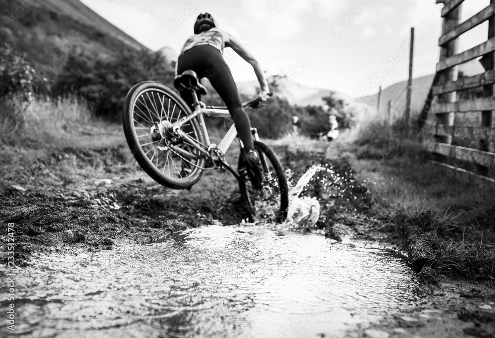 女自行车手在水坑上骑行