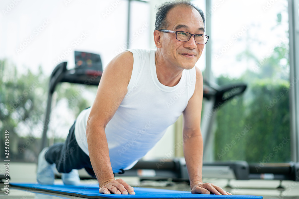 老年人在健身馆做俯卧撑。成熟健康的生活方式。