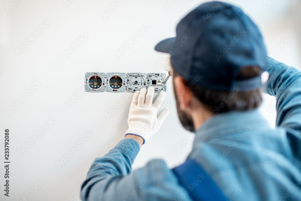 电工在室内白墙上统一安装电气插座