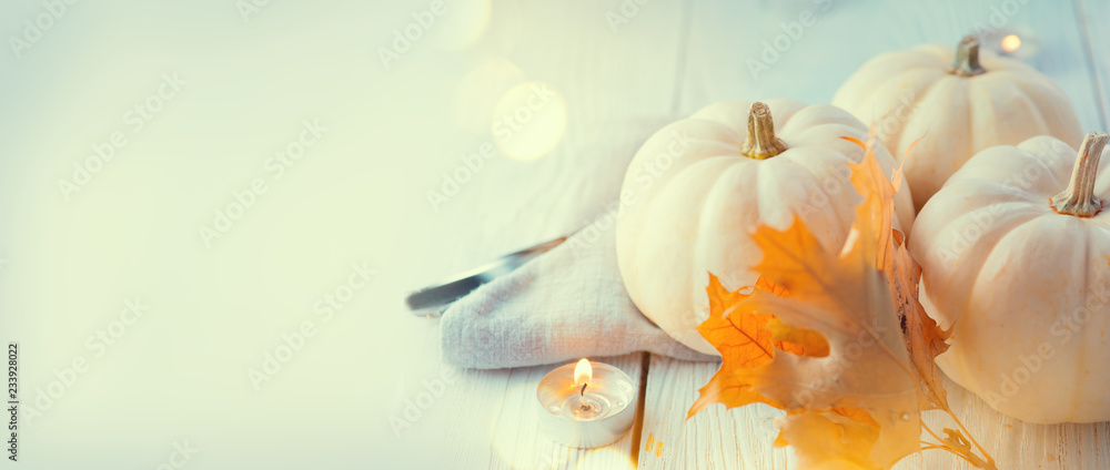 感恩节背景。节日场景。木制桌子，用南瓜、秋叶和罐头装饰