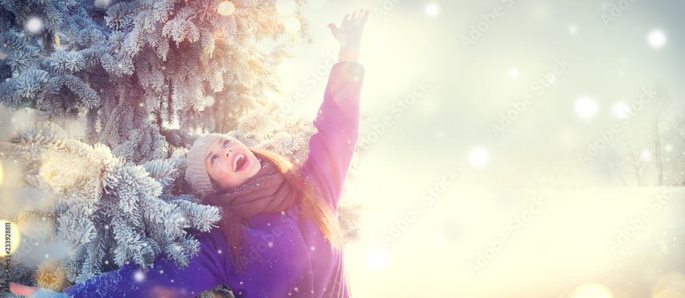 圣诞场景。冬日快乐的美丽女孩在装饰过的克里斯的带领下在冬季公园户外玩得很开心