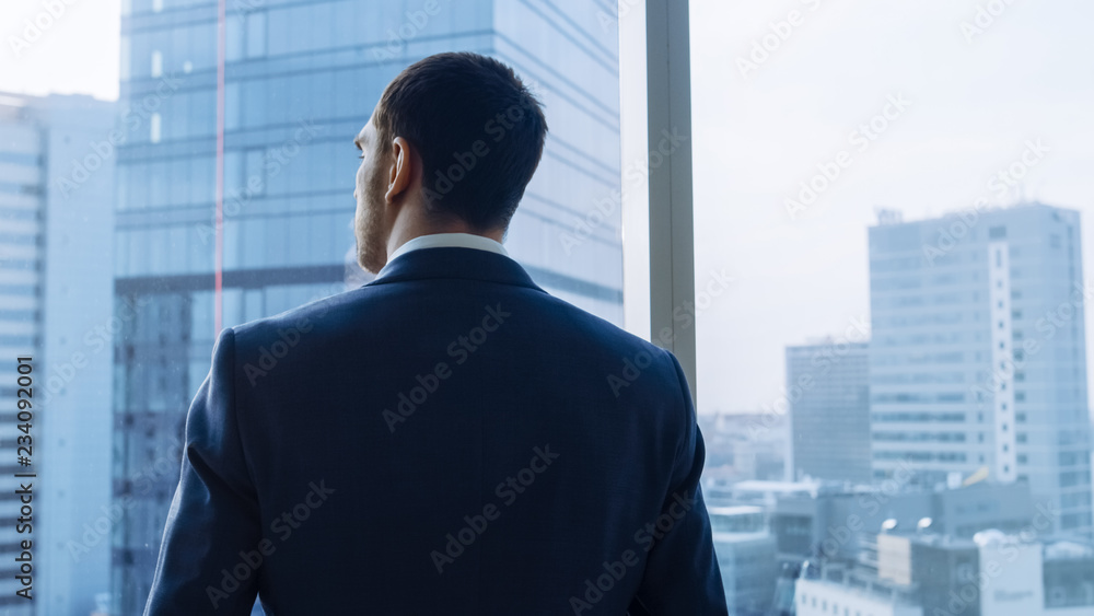 穿着西装的成功商人站在办公室里思考下一个大人物的中景