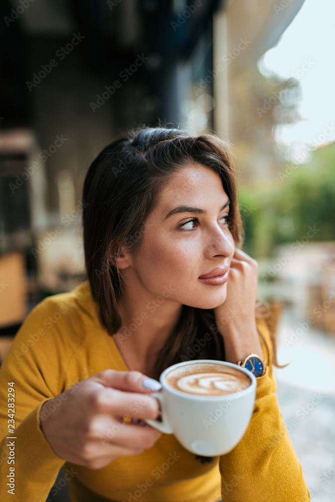 美丽的女孩在喝咖啡。