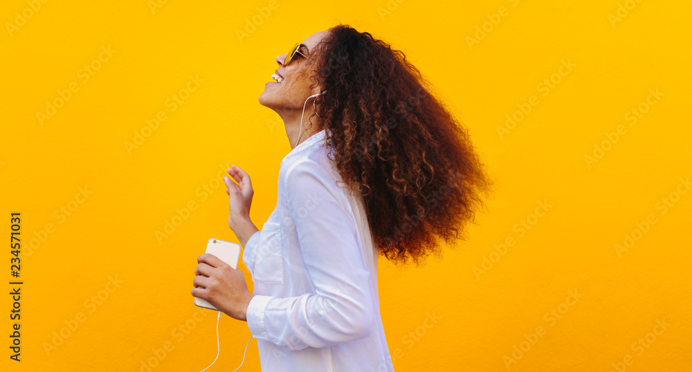 非洲女孩在智能手机上听音乐玩得很开心