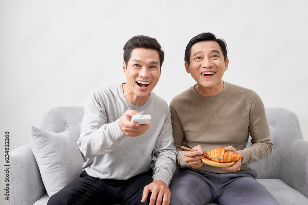 两个快乐的男人在家里看电视喜剧电影，复制空间