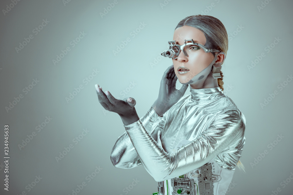 未来派银色半机械人在灰色的未来科技公司上用手比划，目光移开