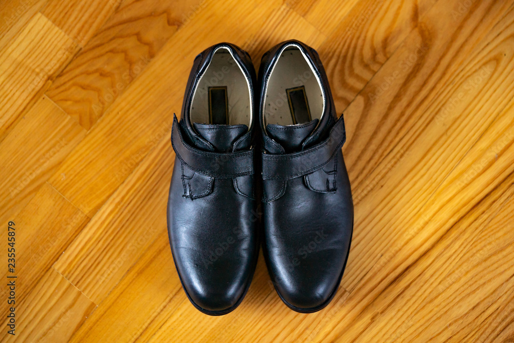 木质背景的新款经典皮鞋。木质表面中央的男鞋俯视图