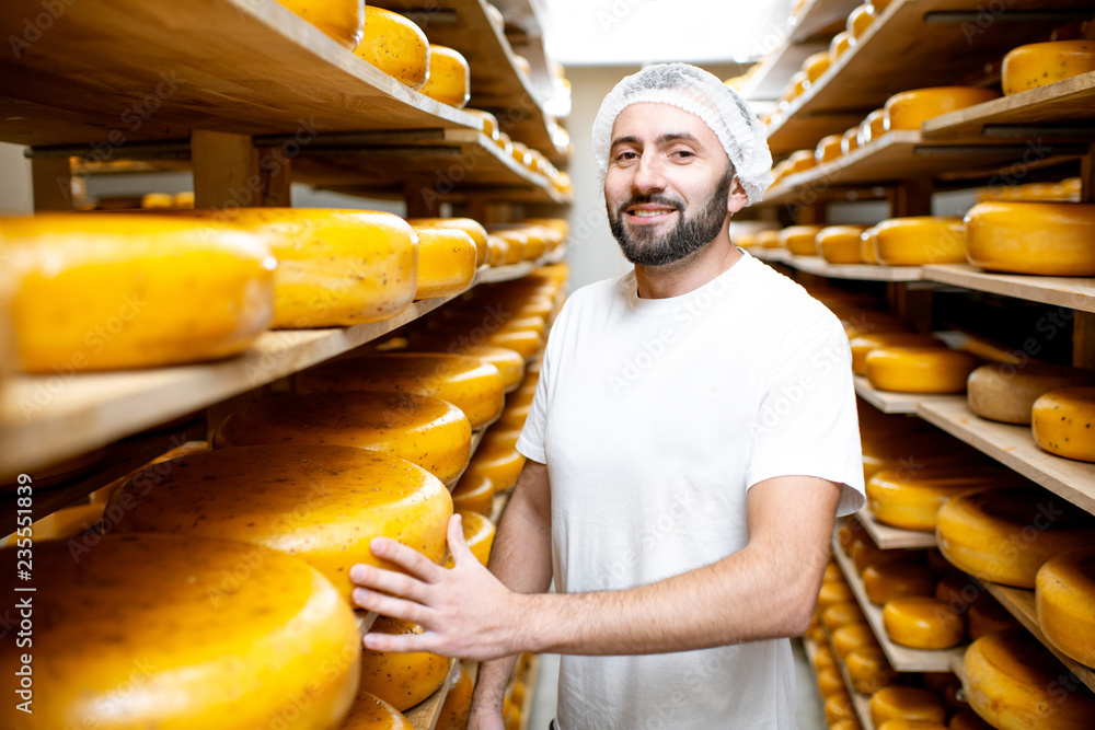储藏室里的奶酪制造商，在陈化过程中货架上摆满了奶酪轮